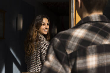 Smiling woman looking at boyfriend while relocating house - MASF43590