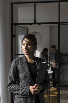 Saleswoman looking away while holding folder at new home - MASF43601