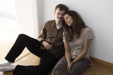 Relaxed multiracial couple sitting with eyes closed at home - MASF43630