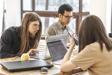 Ein Team von Programmierern arbeitet an Laptops im Kreativbüro - EVKF00098