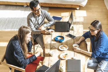 IT colleagues sitting at table discussing startup in office - EVKF00111