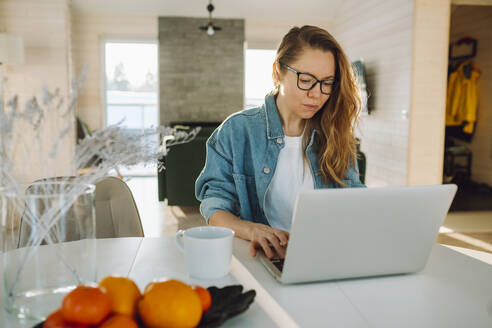 Freiberufler arbeitet am Laptop im Home Office - OLRF00214