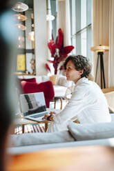 Geschäftsfrau mit Laptop in der Hotellobby - MDOF01882
