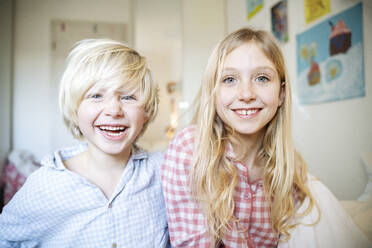 Happy blond siblings in pajamas at home - NJAF00861