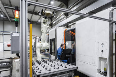Wartungsingenieur, der CNC-Roboter in einer modernen Produktionsstätte bedient - AAZF01697