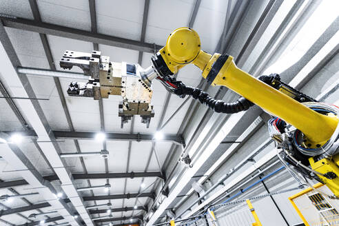 Yellow robotic arm in illuminated modern factory - AAZF01705