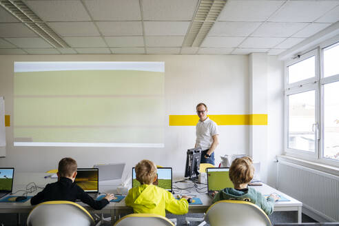 Professor unterrichtet Jungen im Computerklassenzimmer der Schule - NJAF00898