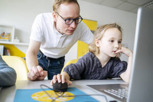 Mädchen benutzt Laptop bei Professor im Klassenzimmer - NJAF00907