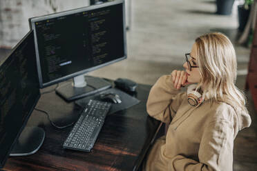 Nachdenklicher Computerprogrammierer, der im Home Office arbeitet - VSNF01725