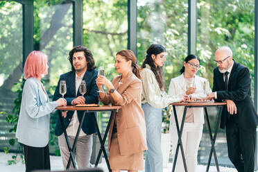 Businessmen and businesswomen making a corporate party after the business conference to celebrate the year goals and achievements. - DMDF10544