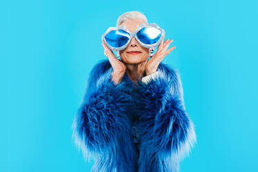 Happy and funny senior old woman wearing fashionable clothing on colorful background- Modern cool fancy grandmother portrait, concepts about elderly and older people - DMDF10636