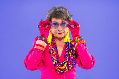 Happy and funny senior old woman wearing fashinable clothing on colorful background- Modern cool fancy grandmother portrait, concepts about elderly and older people - DMDF10664