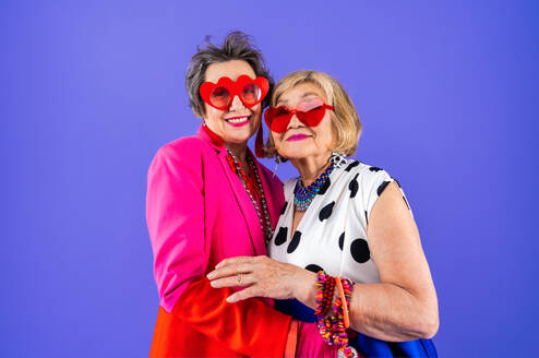 Happy and funny senior old women wearing fashinable clothing on colorful background- Modern cool fancy grandmothers portrait, concepts about elderly and older people - DMDF10695