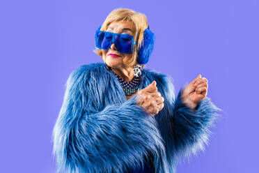 Happy and funny senior old woman wearing fashinable clothing on colorful background- Modern cool fancy grandmother portrait, concepts about elderly and older people - DMDF10702