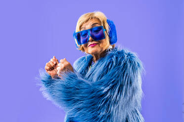 Happy and funny senior old woman wearing fashinable clothing on colorful background- Modern cool fancy grandmother portrait, concepts about elderly and older people - DMDF10703