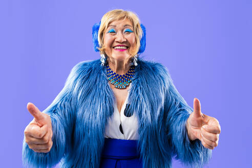 Happy and funny senior old woman wearing fashinable clothing on colorful background- Modern cool fancy grandmother portrait, concepts about elderly and older people - DMDF10707