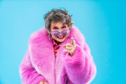 Happy and funny senior old woman wearing fashinable clothing on colorful background- Modern cool fancy grandmother portrait, concepts about elderly and older people - DMDF10756
