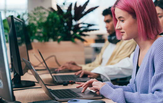 Cinematic image of a programming office with young programmers working on a new project for a start up business. - DMDF10771