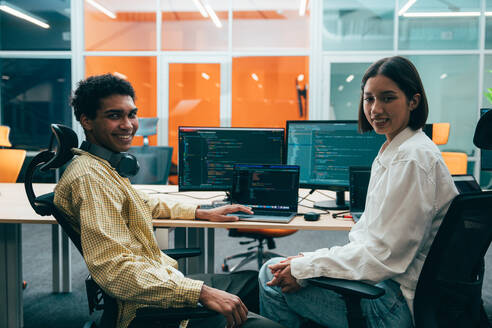 Cinematic image of a programming office with young programmers working on a new project for a start up business. - DMDF10787