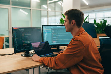 Cinematic image of a programming office with young programmers working on a new project for a start up business. - DMDF10795