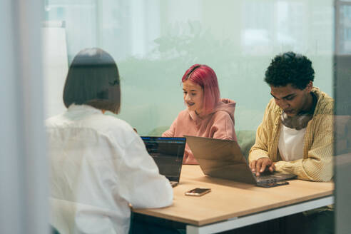 Cinematic image of a programming office with young programmers working on a new project for a start up business. - DMDF10806