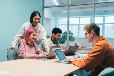 Cinematic image of a programming office with young programmers working on a new project for a start up business. - DMDF10811