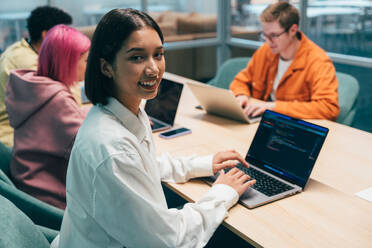 Cinematic image of a programming office with young programmers working on a new project for a start up business. - DMDF10812