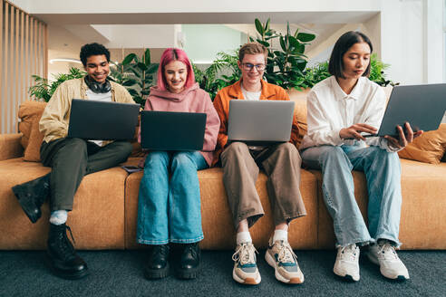 Cinematic image of a programming office with young programmers working on a new project for a start up business. - DMDF10817