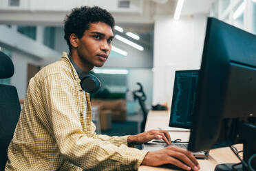 Cinematic image of a programming office with young programmers working on a new project for a start up business. - DMDF10848