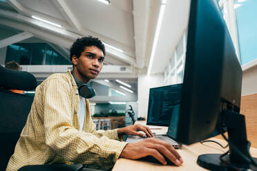 Cinematic image of a programming office with young programmers working on a new project for a start up business. - DMDF10849