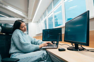 Cinematic image of a programming office with young programmers working on a new project for a start up business. - DMDF10850