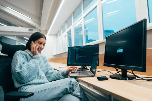 Cinematic image of a programming office with young programmers working on a new project for a start up business. - DMDF10851