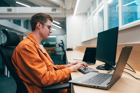 Cinematic image of a programming office with young programmers working on a new project for a start up business. - DMDF10859