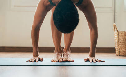 Beautiful sporty girl making yoga training in the gym studio. Young woman coach with short hair performing yoga and acroyoga poses, warming up for the class. Concepts of healthy lifestyle and sport disciplines - DMDF10938