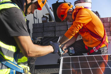 Mitarbeiter bei der Installation von Solarzellen auf dem Dach - PCLF00981