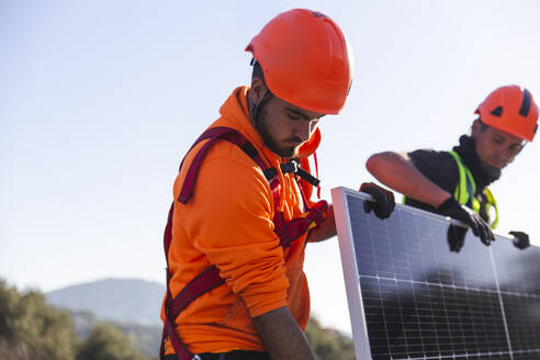 Zwei Arbeiter bei der Installation eines Solarpanels - PCLF00990