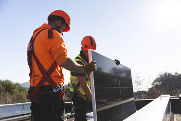 Zwei Ingenieure bei der Installation von Solaranlagen auf dem Dach3 - PCLF00991