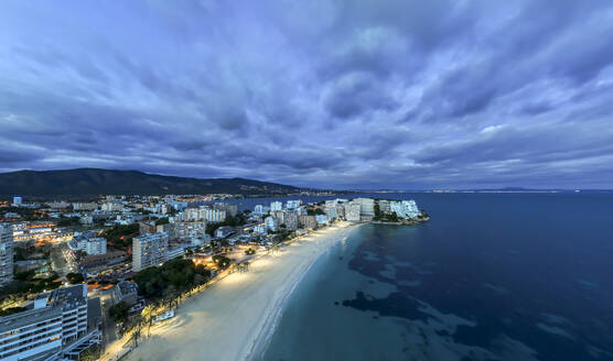 Spanien, Balearen, Magaluf, Luftaufnahme von Stadt und Strand auf der Insel Mallorca in der Abenddämmerung - AMF09995