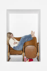 Teenage girl resting on chairs by white background - PSTF01131