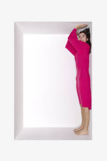 Teenager-Mädchen in rosa Kleid steht in einer Nische - PSTF01183