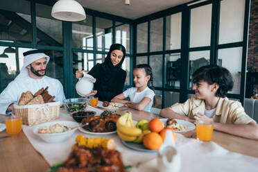 Traditional arabian family from Dubai spending time together at home. Concept about, emirati culture, parenthood, adoption and family lifestyle - DMDF10967
