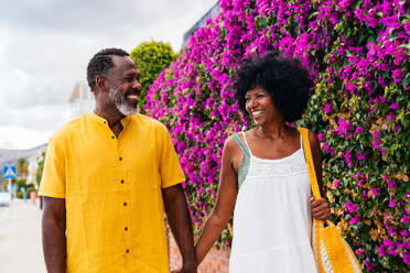 Beautiful mature black couple of lovers dating at the seaside - Married african middle-aged couple bonding and having fun outdoors, concepts about relationship, lifestyle and quality of life - DMDF10981