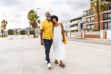 Beautiful mature black couple of lovers dating at the seaside - Married african middle-aged couple bonding and having fun outdoors, concepts about relationship, lifestyle and quality of life - DMDF10989