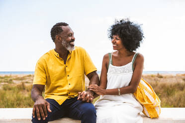 Beautiful mature black couple of lovers dating at the seaside - Married african middle-aged couple bonding and having fun outdoors, concepts about relationship, lifestyle and quality of life - DMDF10994