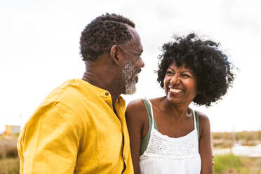 Beautiful mature black couple of lovers dating at the seaside - Married african middle-aged couple bonding and having fun outdoors, concepts about relationship, lifestyle and quality of life - DMDF10997