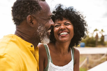 Beautiful mature black couple of lovers dating at the seaside - Married african middle-aged couple bonding and having fun outdoors, concepts about relationship, lifestyle and quality of life - DMDF10998