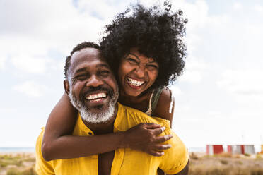 Beautiful mature black couple of lovers dating at the seaside - Married african middle-aged couple bonding and having fun outdoors, concepts about relationship, lifestyle and quality of life - DMDF11016