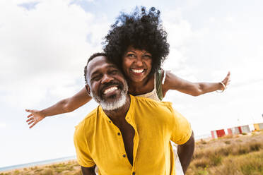 Beautiful mature black couple of lovers dating at the seaside - Married african middle-aged couple bonding and having fun outdoors, concepts about relationship, lifestyle and quality of life - DMDF11018