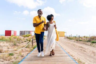 Beautiful mature black couple of lovers dating at the seaside - Married african middle-aged couple bonding and having fun outdoors, concepts about relationship, lifestyle and quality of life - DMDF11024