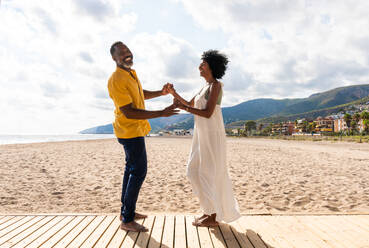 Beautiful mature black couple of lovers dating at the seaside - Married african middle-aged couple bonding and having fun outdoors, concepts about relationship, lifestyle and quality of life - DMDF11043